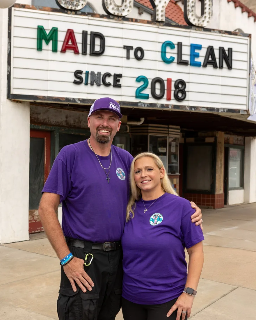 Owners JJ and Melanie Barnhill in Maid to Clean shirts under the JOYO Theatre marquee
